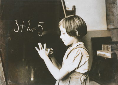 876940 Afbeelding van een meisje dat een rekensom gemaakt heeft op het schoolbord in een klaslokaal van de Piusschool ...